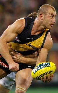 AFL 2014 Rd 20 - Richmond v Essendon Matt Thomas of the Tigers is tackled by Ben Howlett of the Bombers during the 2014 AFL Round 20 match between the Richmond Tigers and the Essendon Bombers at the MCG, Melbourne on August 08, 2014. (Photo: Michael Willson/AFL Media)